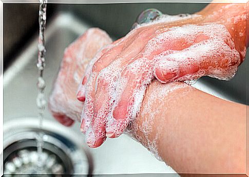 Person washing hands with soap and water.